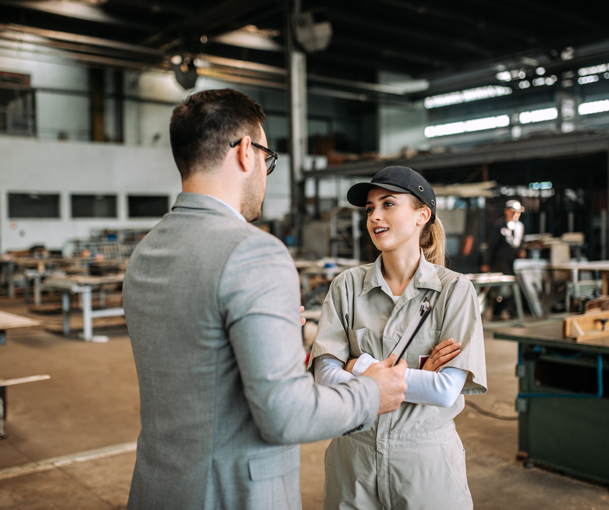 Manager talking with a worker on a manufacturing plant floor